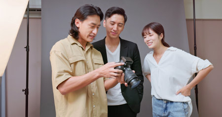 Asian photographer explaining detail to model and assistant about projectの写真素材