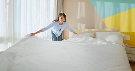 asian woman changes bed quilt in bedroom and it is fresh and comfortable