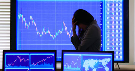 Rear silhouette view - Female Asian stock market analyst is facing failure losing profit reaching down limit crisisの写真素材