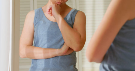 asian unhappy woman is dissatisfied her chest and breast in front of mirror