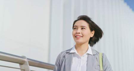 Asian confident business woman walking on sidewalk during commute
