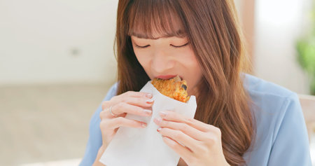 unhealthy food - asian girl eat fried chicken cutlet and enjoy it very much