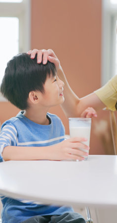asian children drink healthy milk grow up happily with parent love and enjoyの写真素材