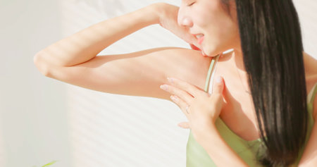 close up view - asian woman is gently touch her armpit feels dryness and comfortableの写真素材
