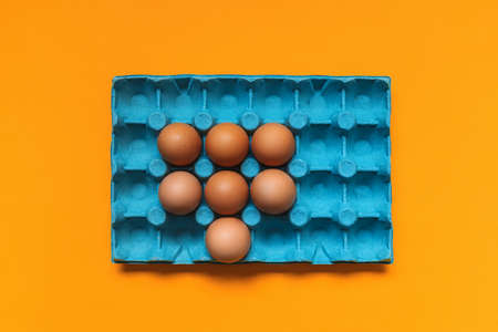 Top view of blue eggbox on orange backgroundの写真素材