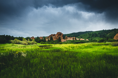 Landscape of a green field with rock formations before a storm.の写真素材