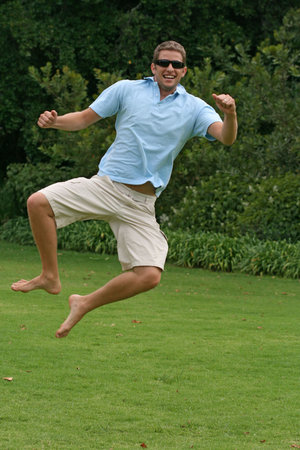 Excited man jumping in air, clicking heels together with happinessの写真素材