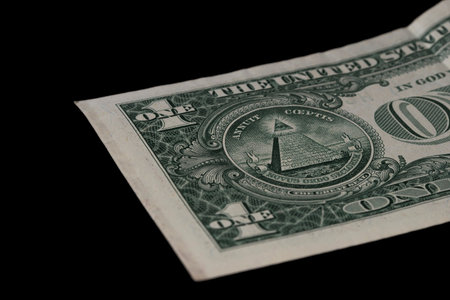 Closeup of a dollar bill on a black background.