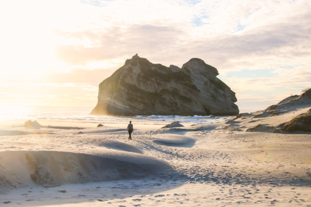 The north facing sandy beach is accessible only via a 20 minute walking track from the end of Wharariki Road. The road end is approximately 4 kilometres from the small village of Pupongaの写真素材
