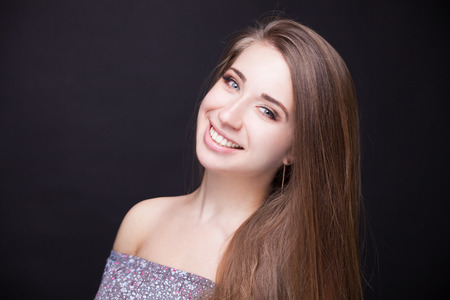 Beautiful Face Makeup closeup. Perfect Healthy Skin.Fashion Beauty Model Girl with Glamor Make-up and Hairstyle over Black Background.の写真素材