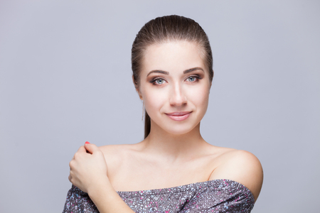 Beautiful Face Makeup closeup. Perfect Healthy Skin.Fashion Beauty Model Girl with Glamor Make-up and Hairstyle over Black Background.の写真素材