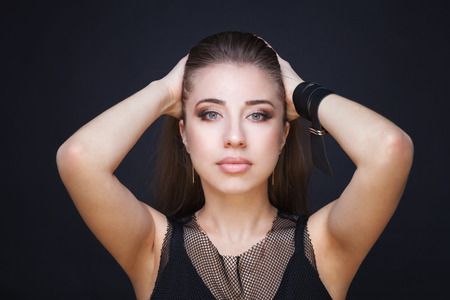 Beautiful Face Makeup closeup. Perfect Healthy Skin.Fashion Beauty Model Girl with Glamor Make-up and Hairstyle over Black Background.の写真素材