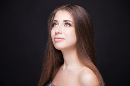 Beautiful Face Makeup closeup. Perfect Healthy Skin.Fashion Beauty Model Girl with Glamor Make-up and Hairstyle over Black Background.の写真素材