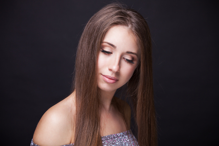 Beautiful Face Makeup closeup. Perfect Healthy Skin.Fashion Beauty Model Girl with Glamor Make-up and Hairstyle over Black Background.の写真素材