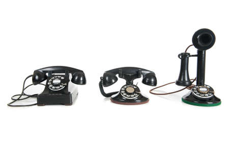 Three black antique phones on a white backgroundの写真素材