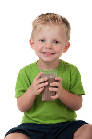 Young happy boy holding chocolate milk in a green shirt on a white backgroundの写真素材