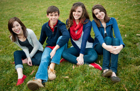 A group of four happy teenagers outsideの写真素材