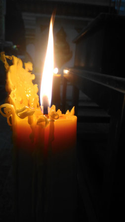 One candle flame light at night with bokeh on dark backgroundの写真素材