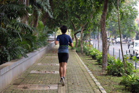 asian young fitness man runner running at the park