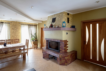 Fireplace and Table in Livingroom with Cups, Lamps and Christmas Tree on Mantelpieceの写真素材