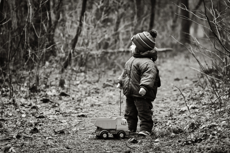 Little Boy With a Car Toy Got Lost In a Forestの写真素材