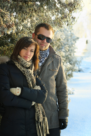 Young Couple Under Fir Trees Winterの写真素材