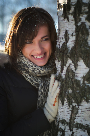Young Woman Near Birch Tree In Winter Sunny Dayの写真素材