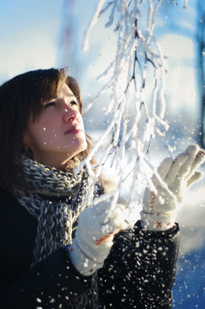Young Woman  Shakes Birch Hoared Branch With Her Handの写真素材