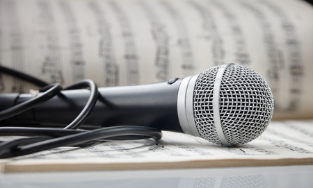 Microphone with cable lying on sheet musicの写真素材