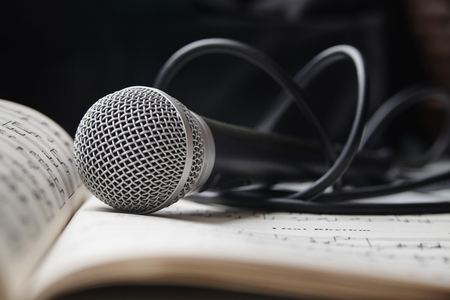 Microphone with cable lying on sheet of musicの写真素材