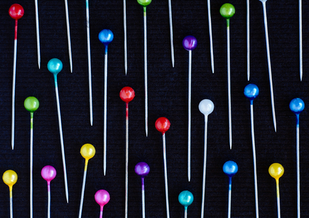 Multicolored pins lying over black backgroundの写真素材