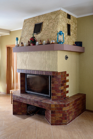 Fireplace in Livingroom with Cups, Lamps and Christmas Tree on Mantelpieceの写真素材