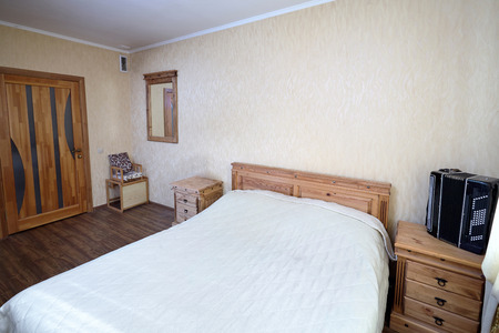 Interior of Bedroom of Rural House with Accordion on Nightstand in Pastel Tonesの写真素材