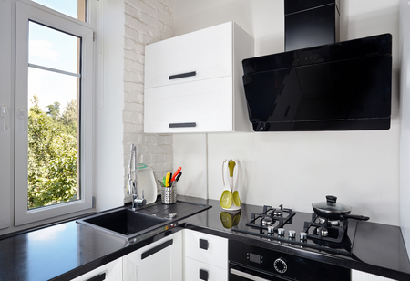 Interior of Contemporary Kitchen with Light Oak Facade and Dark Countertopの写真素材