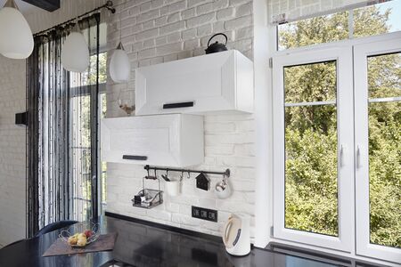 Part of Interior of Contemporary Kitchen with Light Oak Facade and Dark Countertopの写真素材
