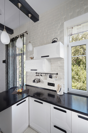 Part of Interior of Contemporary Kitchen with Light Oak Facade and Dark Countertopの写真素材