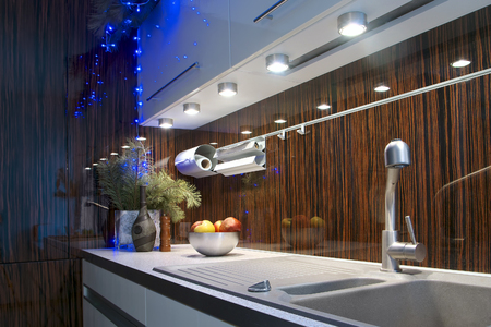 Worktop stone sink and mixer in a fashionable kitchen in brown tones with a tile of garland vase and pine branches on the eve of Christmas and New Yearの写真素材