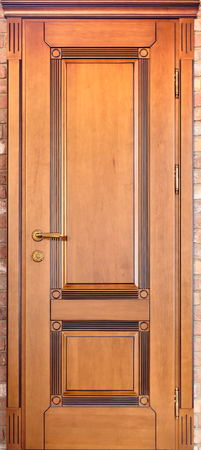 Wooden interior door of maple wood with brass handle and with geometric ornament on brick backgroundの写真素材