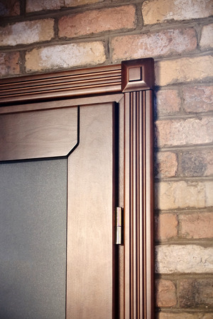 Element of a wooden door brown color carved in classical style on brick wall backgroundの写真素材