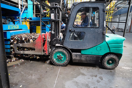 GRODNO, BELARUS - OCTOBER 2018: Pressed rubbish for further processing, sorted pressed separated and processed garbage loaded by forklift at waste recycling plant.のeditorial素材