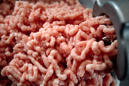 Minced meat coming out from grinder close-up. Healthy fresh homemade minced meat texture. Place for copyspace.の写真素材