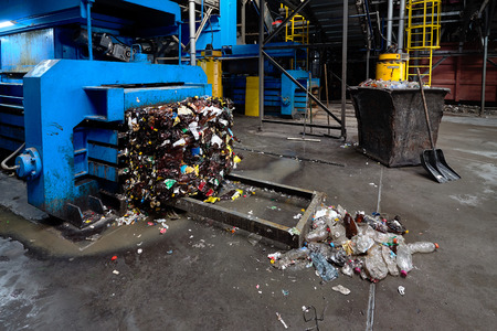 Modern waste sorting and recycling plant, hydraulic press makes wired bale from pressed PET bottles for processing and reuse of plastic. Concept of environment defence materials reuse.の写真素材