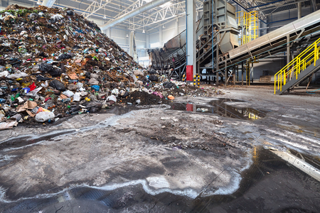 Solving problem of environmental pollution with waste at garbage processing plant - huge pile of garbage prepared for loading to conveyor belt for further sorting and processing with copyspase.の写真素材