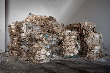 Compressed bales of used polyethylene packaged for further processing workshop of a modern waste recycling plant with copy space. Concept of renewability of raw materials and environment protection.の写真素材