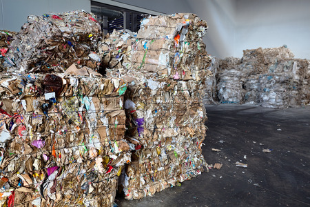 Used cardboard polyethylene and plastic pressed into bales at finished products warehouse on modern waste sorting and processing plant. Concept separate garbage collection and environment protection.の写真素材