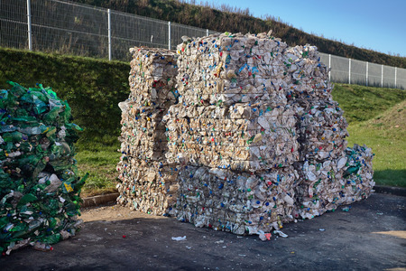 Modern waste sorting and recycling plant. Bales of dairy and drink bottles garbage in recycling plant yard prepared for shipment and reuse. Concept of recycling material and environmental protection.の写真素材