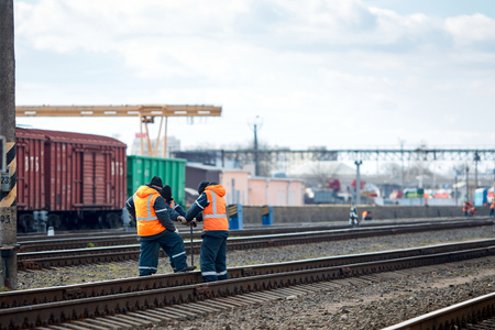 Employees of railway depot inspect repair and maintenance of railway rails in order to detect breakdowns and ensure safety of trains on railway movement with copy space.の写真素材