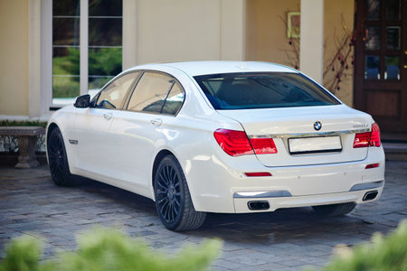 Grodno, Belarus, May 16, 2013: Modern luxury BMW 750Li XDrive car three-quarter upper view parked on stone paved parking near ancient house.のeditorial素材