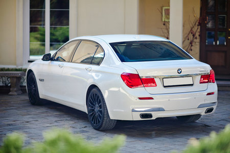 Grodno, Belarus, May 16, 2013: Modern luxury BMW 750Li XDrive car three-quarter upper view parked on stone paved parking near ancient house.のeditorial素材