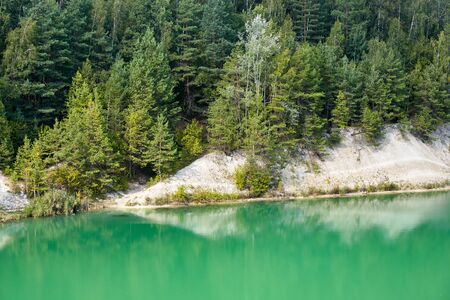 Deserted beach with clear turquoise water on old lake formed on site of chalk quarry in Grodno Belarus in summer sunny day with copy spaceの写真素材
